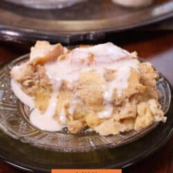 a slice of bread pudding on a plate next to a jar of whiskey sauce.