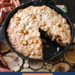 a skillet cookie made with oats and butterscotch chips on a table next to an orange napkin.