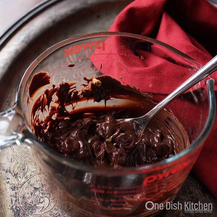 mixing melted chocolate in a glass bowl.