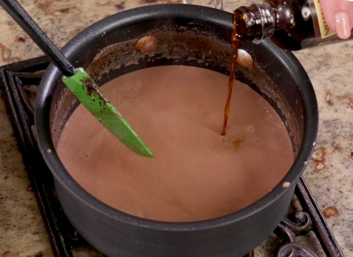 pouring vanilla into hot chocolate.