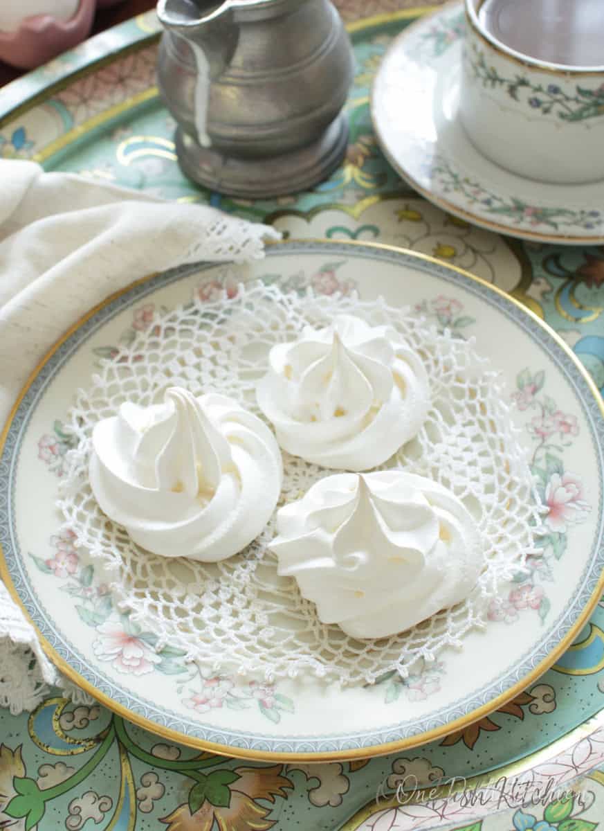 three meringue cookies on a plate.