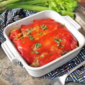white square baking dish that contains a meatloaf covered in red sauce.