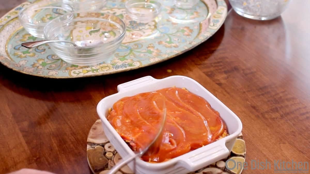 spreading glaze on an unbaked meatloaf.