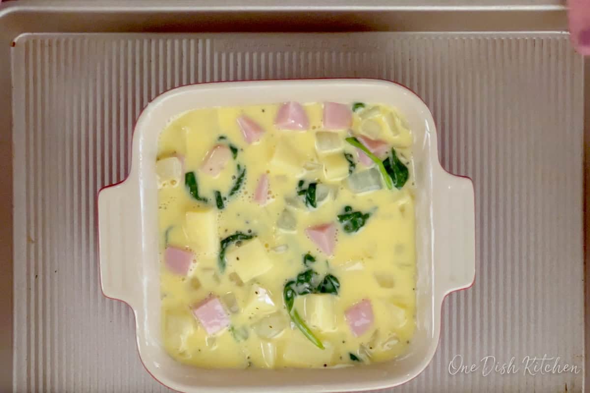 unbaked spinach quiche in a baking dish.