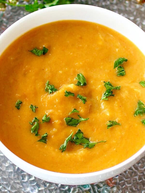 a small batch of curried butternut squash soup in a white bowl.