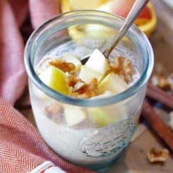 a bowl of overnight oats topped with apples and pecans