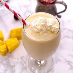 Pina Colada Smoothie in a glass with whipped cream on top.