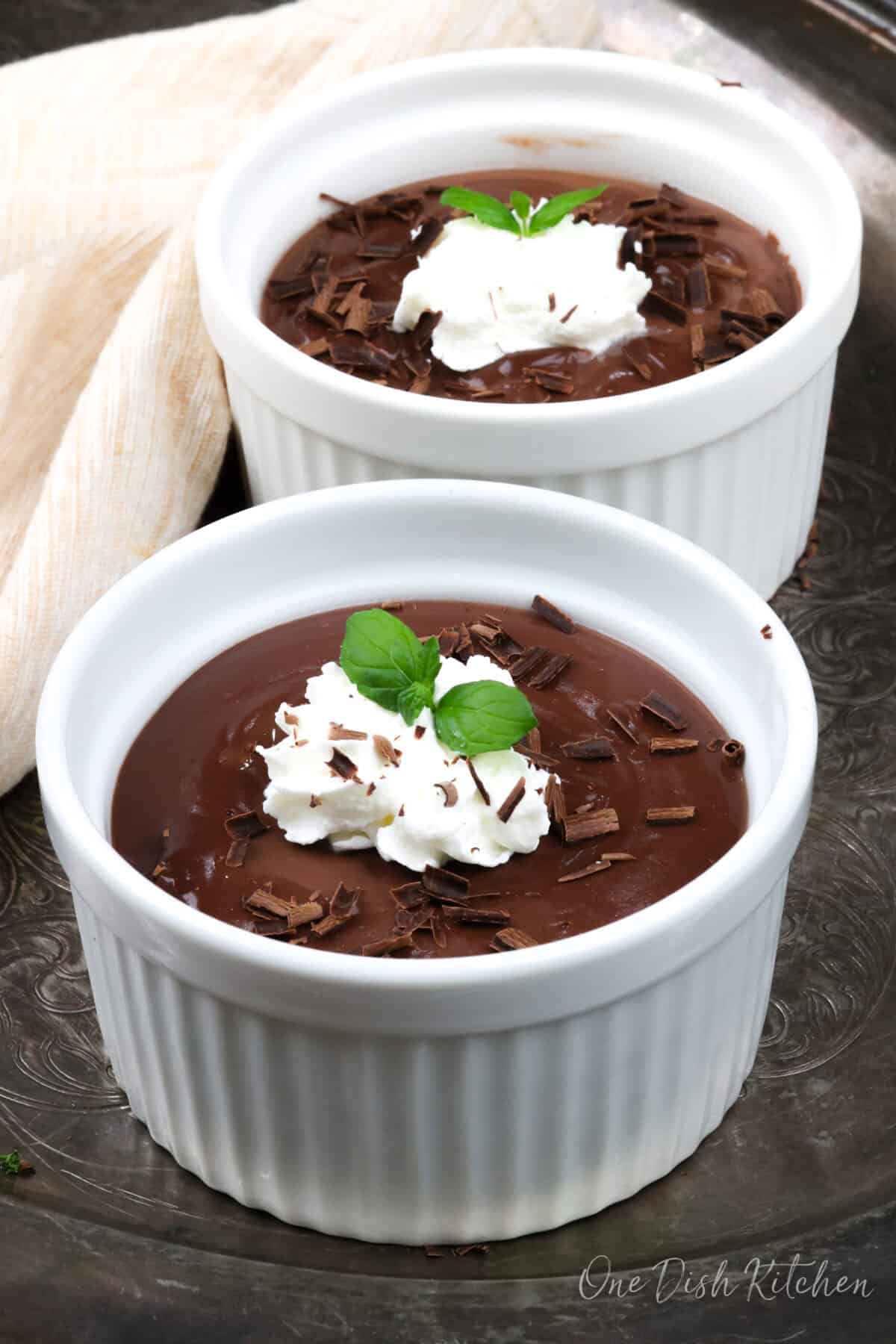 two ramekins filled with chocolate pudding.