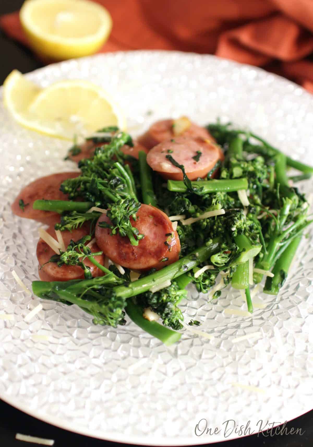 a white plate with broccoli and cooked sausage pieces.