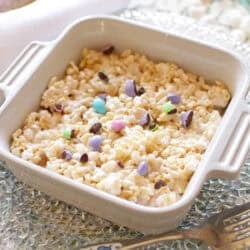 A finished individual Rice Krispie snack bar in a 5-inch baking dish, garnished with colorful chocolate candies, ready to be served.