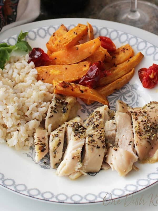 sheet pan chicken and vegetables on a white plate.