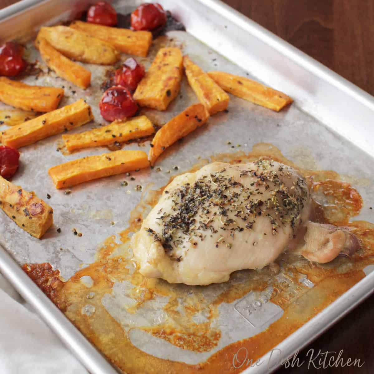 chicken and vegetables cooked on a sheet pan.