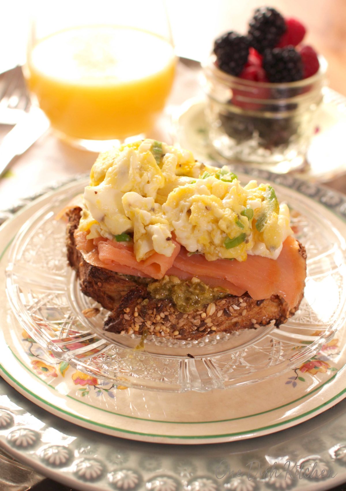 smoked salmon over a layer of pesto on a small piece of french bread topped with scrambled eggs