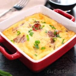 a small crustless quiche lorraine in a red baking dish.
