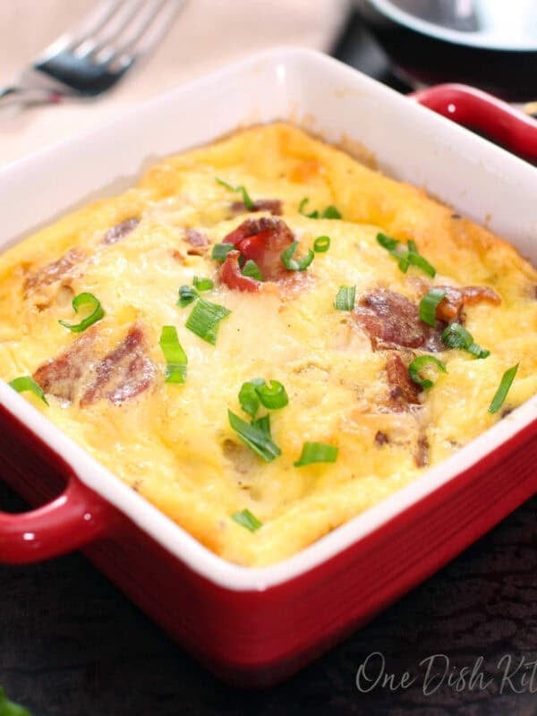 a small crustless quiche lorraine in a red baking dish.