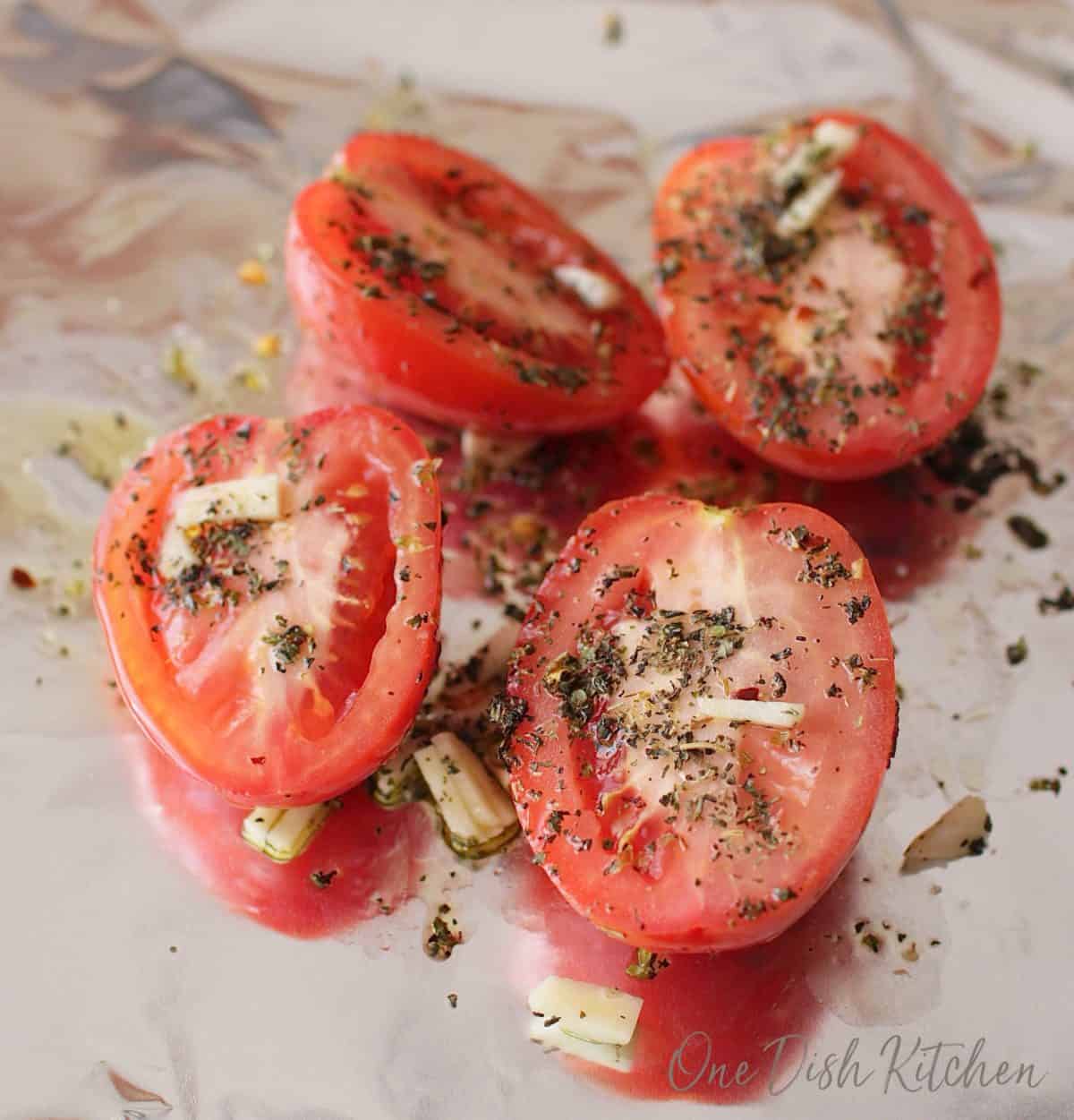 tomatoes sliced in half and place on aluminum foil and topped with seasoning and olive oil.