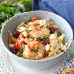 single serving mediterranean shrimp pasta with olives and feta cheese in a bowl.