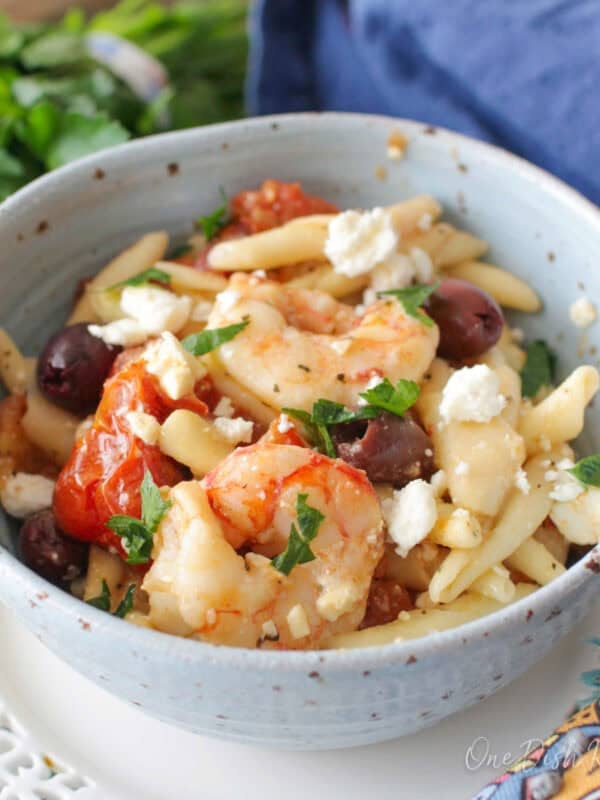 single serving mediterranean shrimp pasta with olives and feta cheese in a bowl.