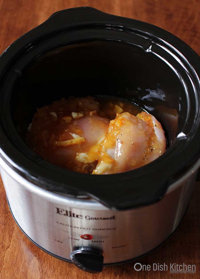Chicken with orange sauce inside a small slow cooker 