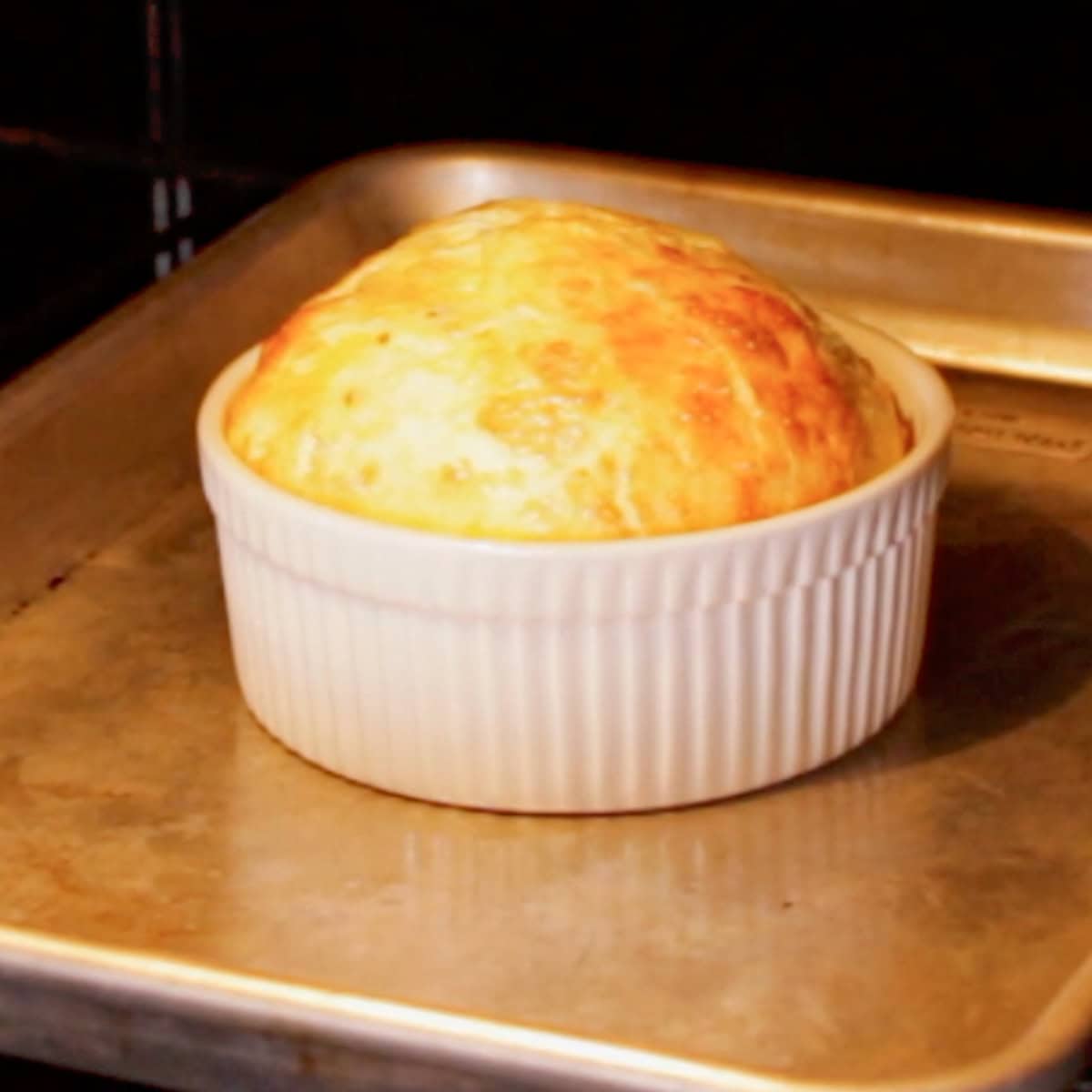 baked eggs with cheese in a ramekin baking in the oven.