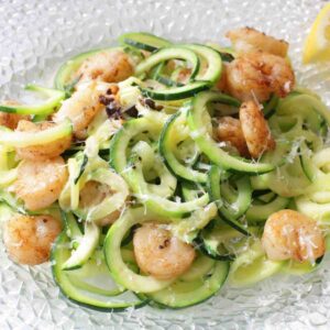 zucchini noodles on a plate with shrimp mixed in.