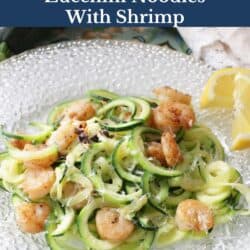 a plate filled with zucchini noodles topped with cooked shrimp.