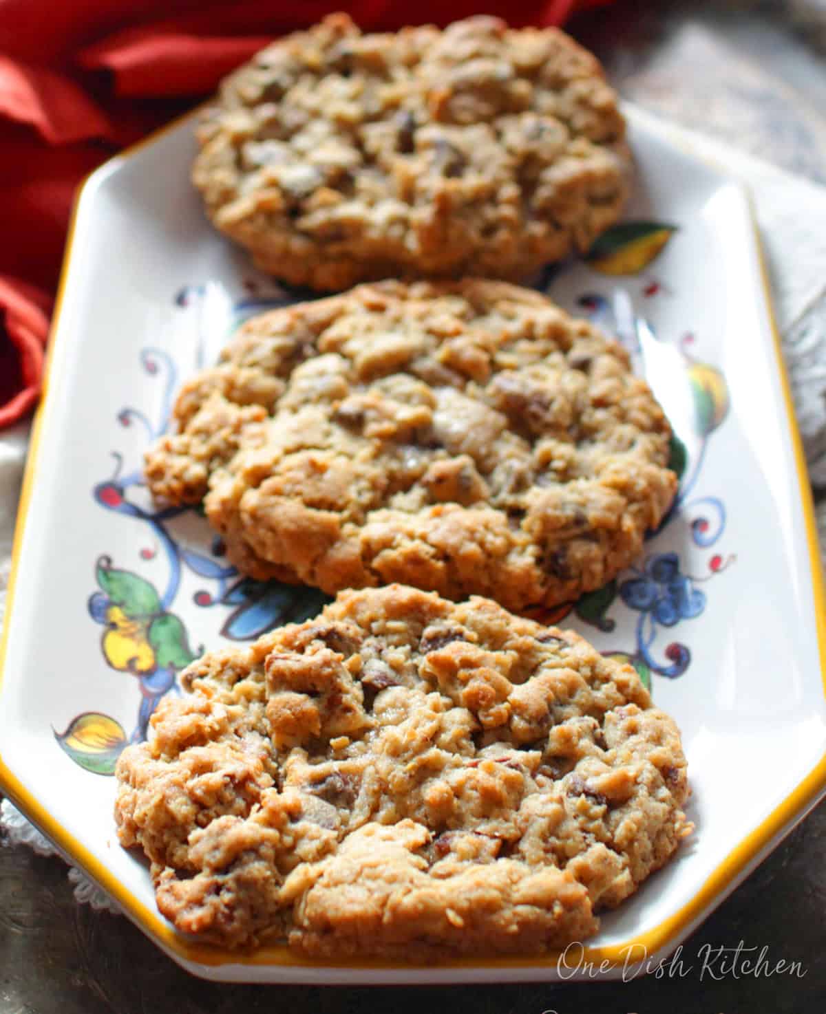 Three large cowboy cookies on a plate.