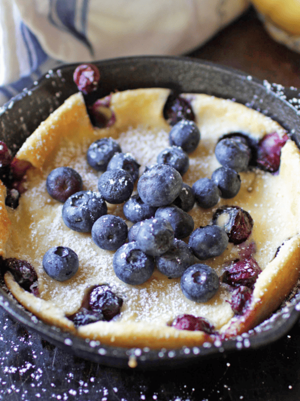 Dutch Baby Pancake with berries on top in mini skillet.
