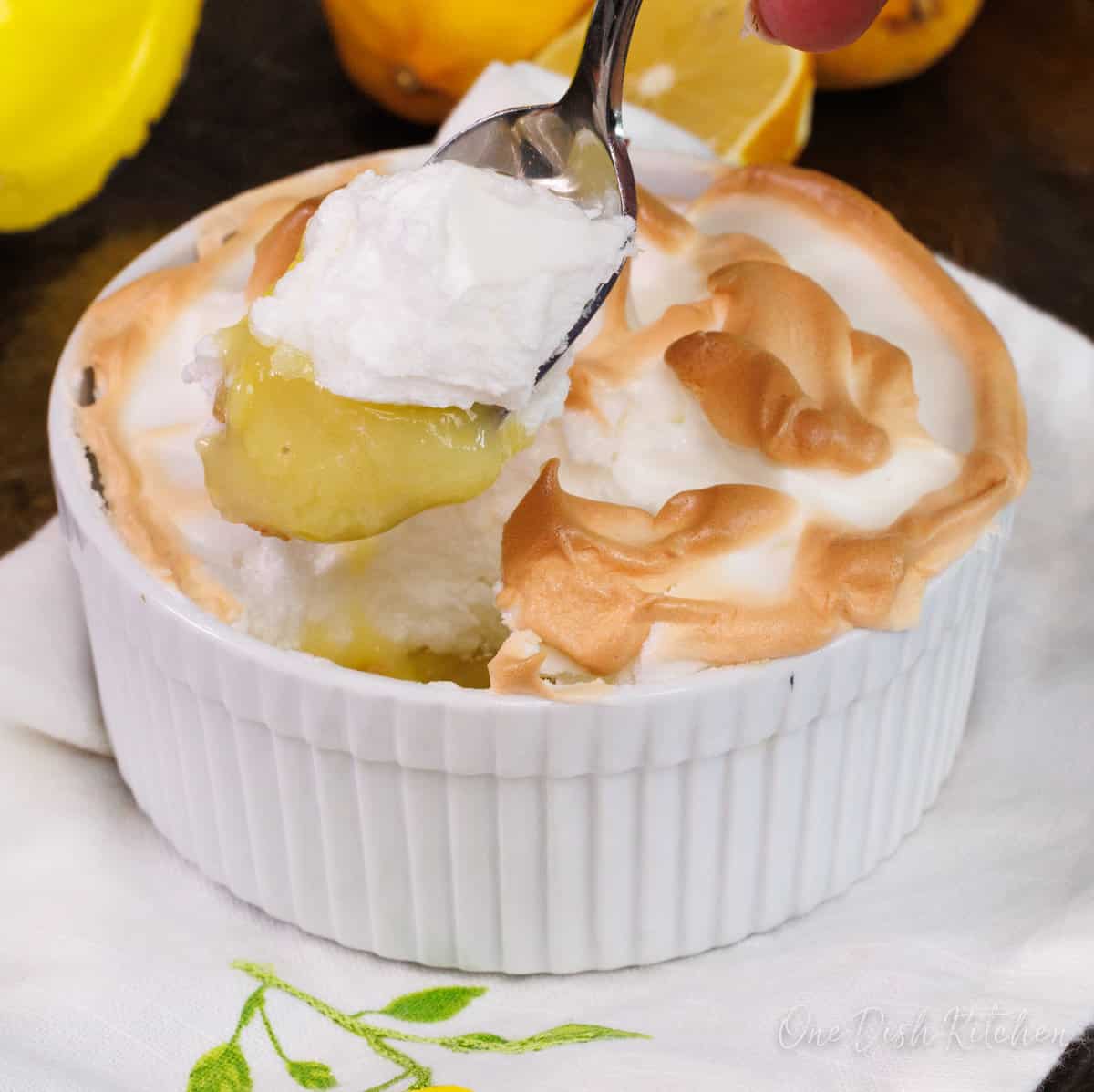 a spoon holding a bite of lemon meringue pie.
