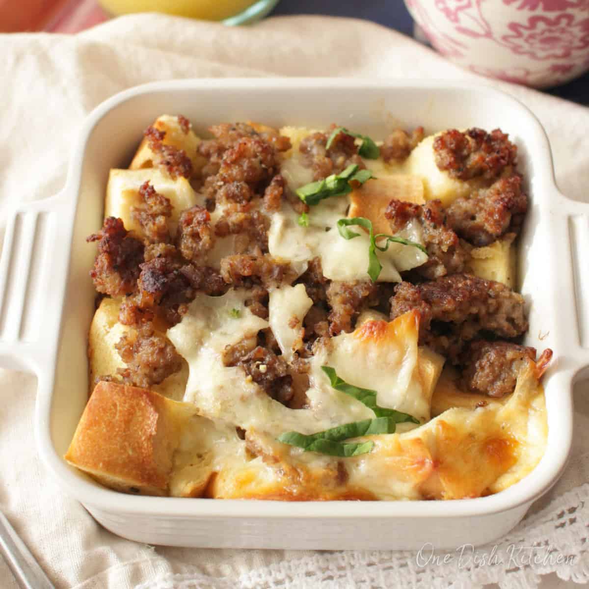a small breakfast casserole with sausage and cheese in a white baking dish.