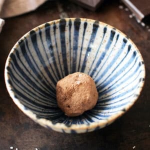 a single chocolate truffle in a blue bowl.