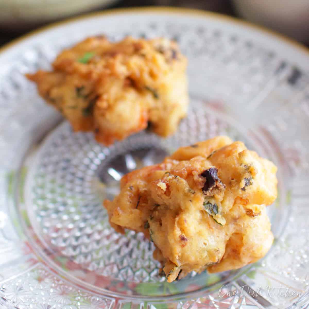 a small batch of crawfish beignets on a plate.