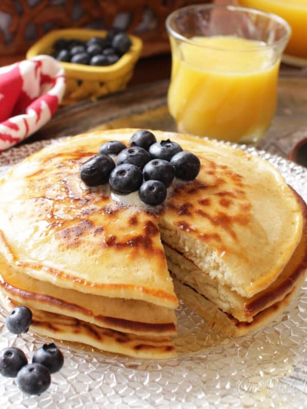 three pancakes on a plate with a fork on the side.