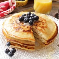 three pancakes on a plate with a fork on the side.
