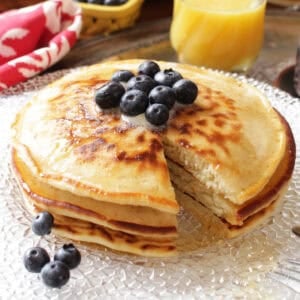 three pancakes on a plate with a fork on the side.