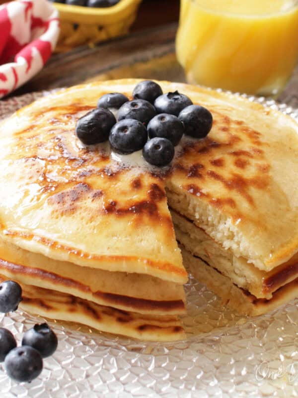 three pancakes on a plate with a fork on the side.