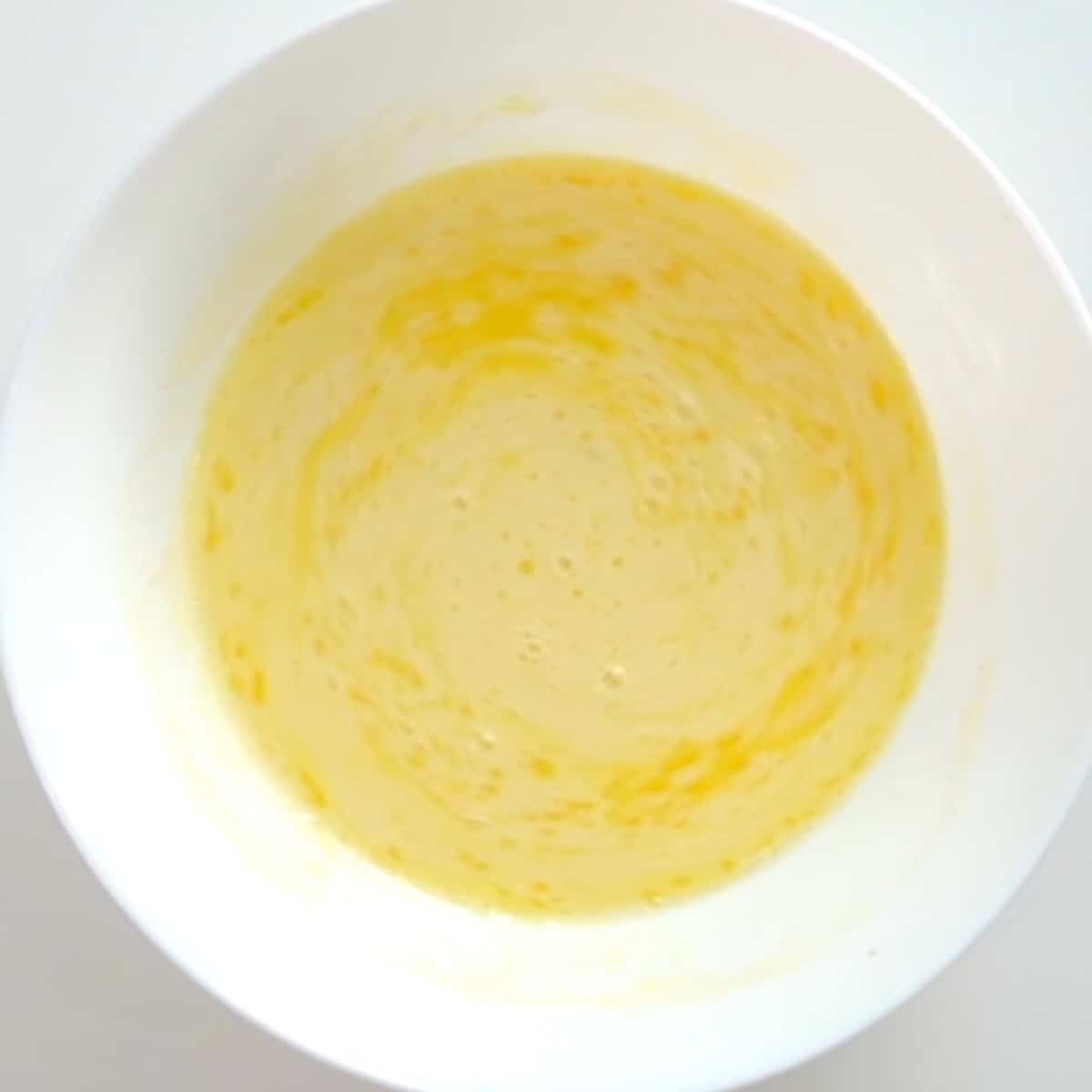 egg, milk, and melted butter in a mixing bowl.