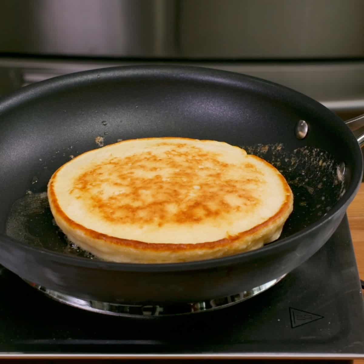 one pancake cooking in a skillet.