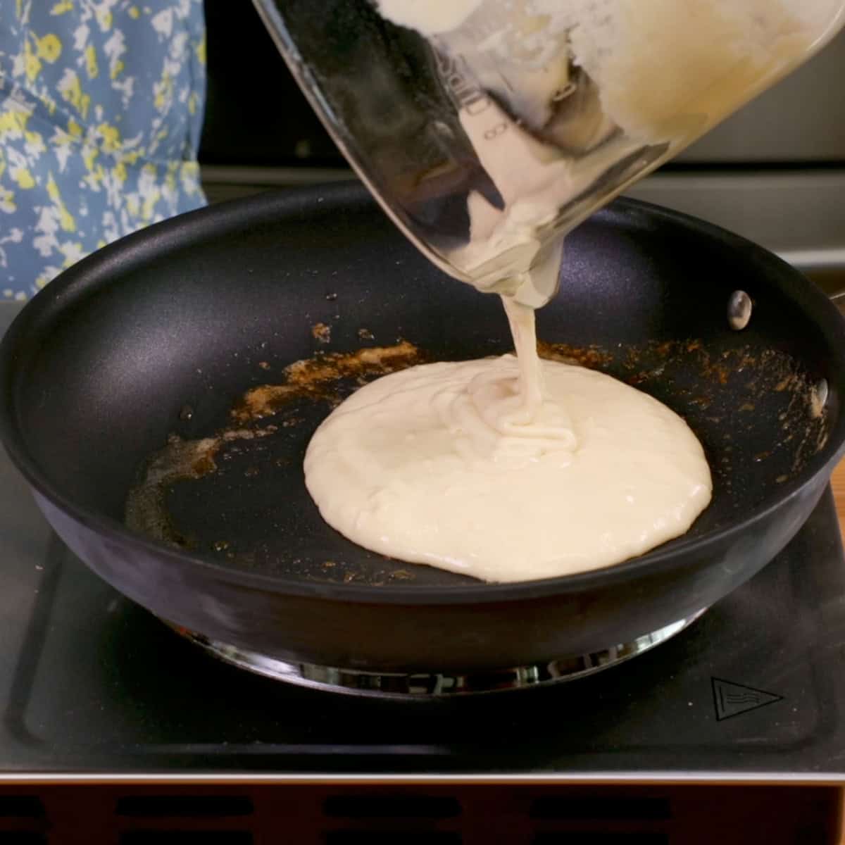 pancake batter being poured into a skillet.