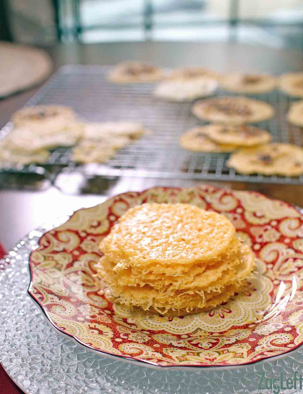 A stack of Parmesan Cheese Crisps on a plate with a cooling rack in the background.