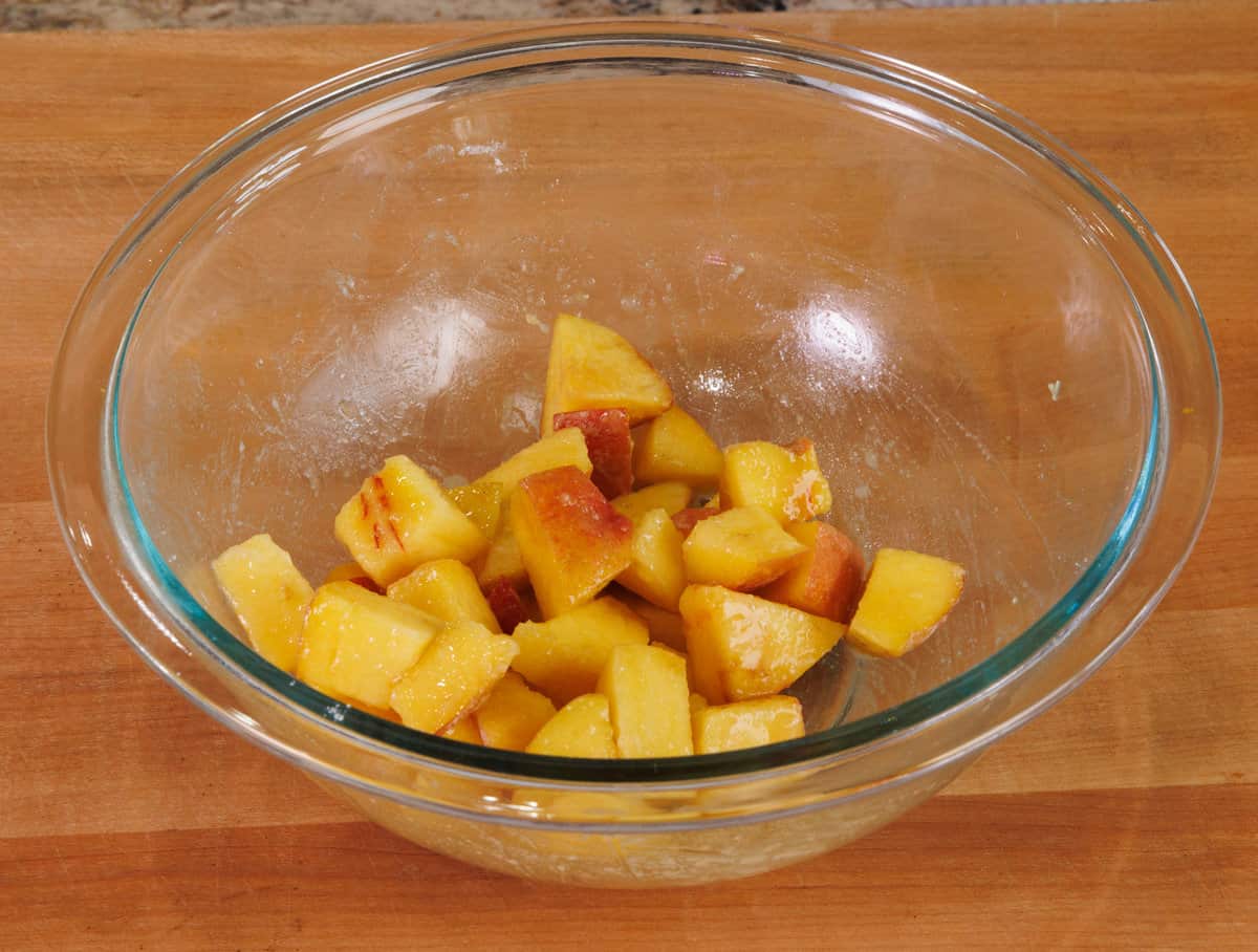 diced peaches and sugar in a mixing bowl.