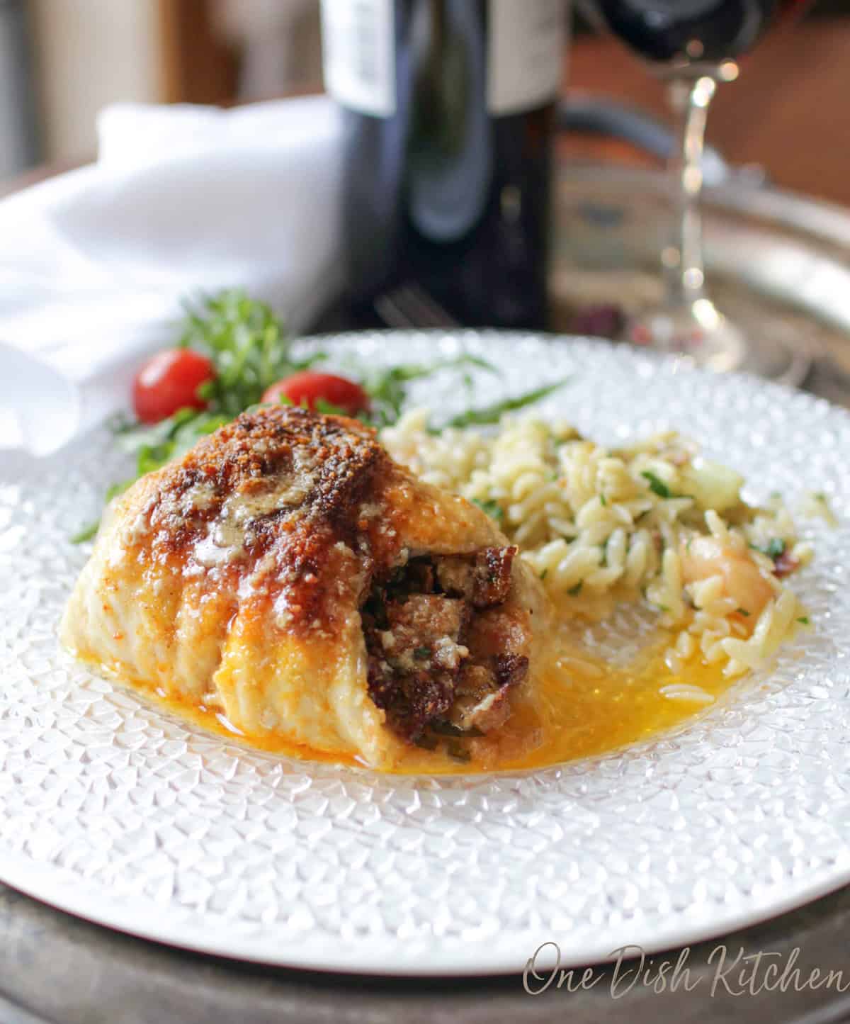 Single serving baked stuffed fish rolled and baked in a small dish, filled with bacon and vegetable stuffing and topped with Parmesan cheese, ready to serve.