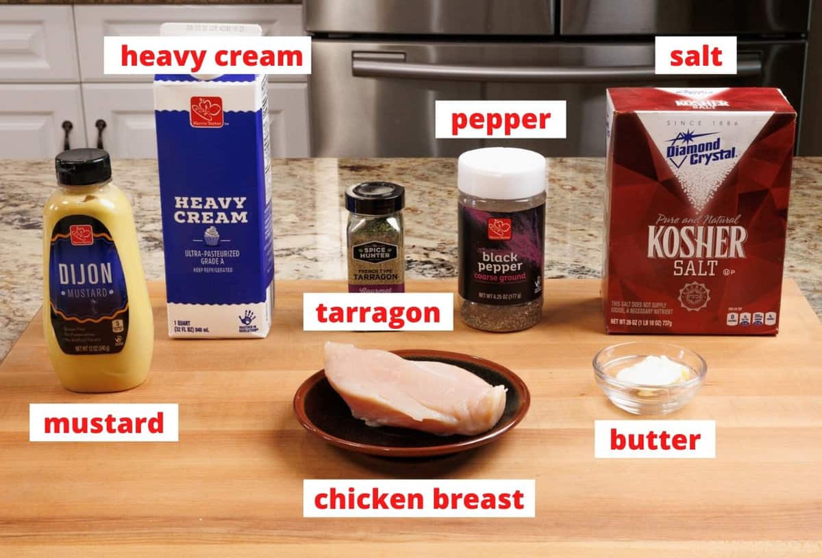 ingredients needed to make mustard chicken on a wooden cutting board.