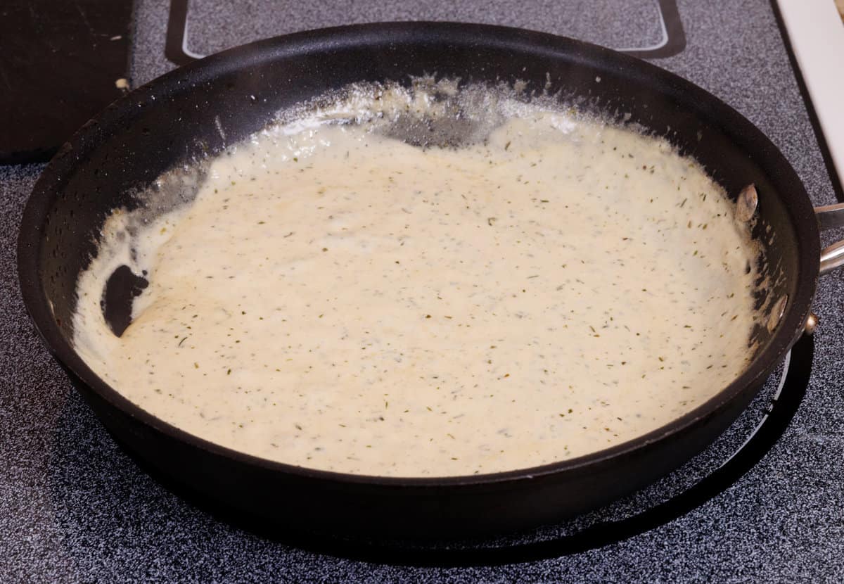 mustard tarragon sauce simmering in a saucepan.