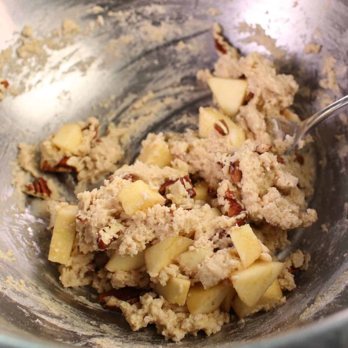 scone batter filled with apples and pecans in a mixing bowl.