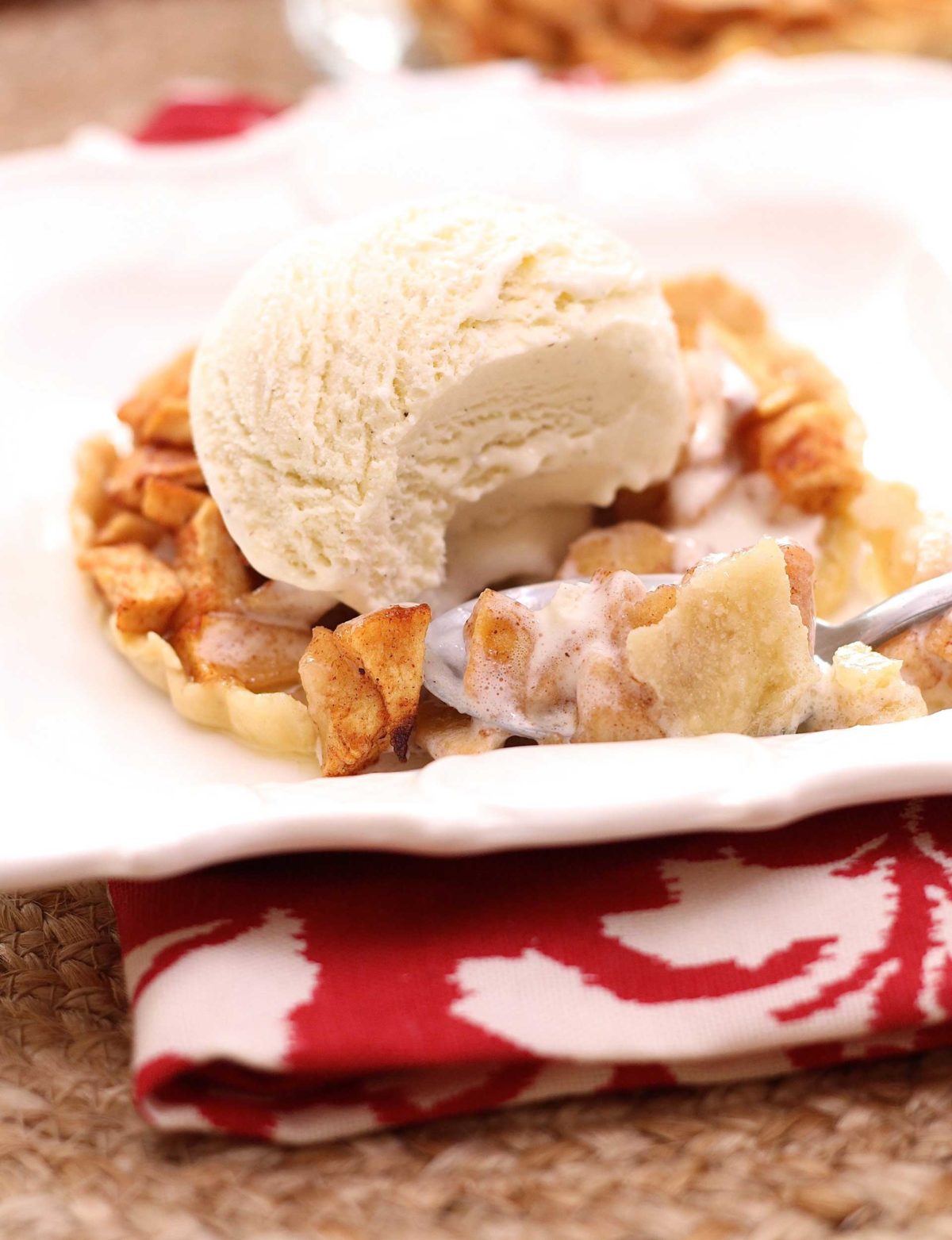 a fork filled with ice cream topped apple pie.