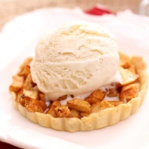 a small apple pie on a plate topped with ice cream