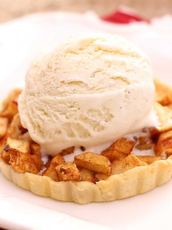 a small apple pie on a plate topped with ice cream