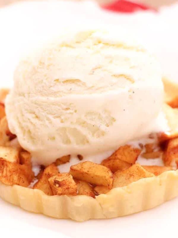 an individual apple pie on a white plate.