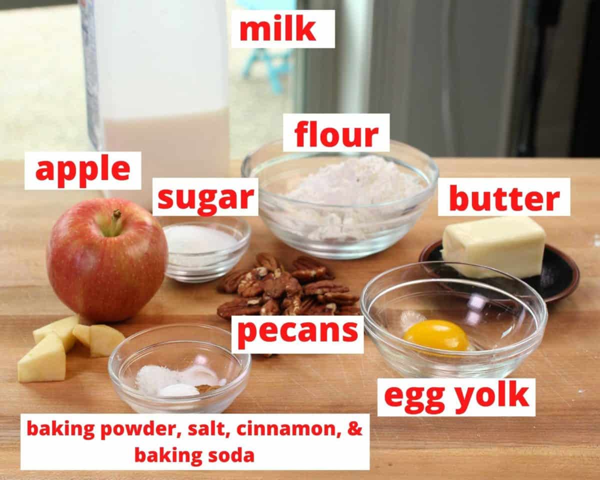 ingredients needed to make apple scones on a brown cutting board.
